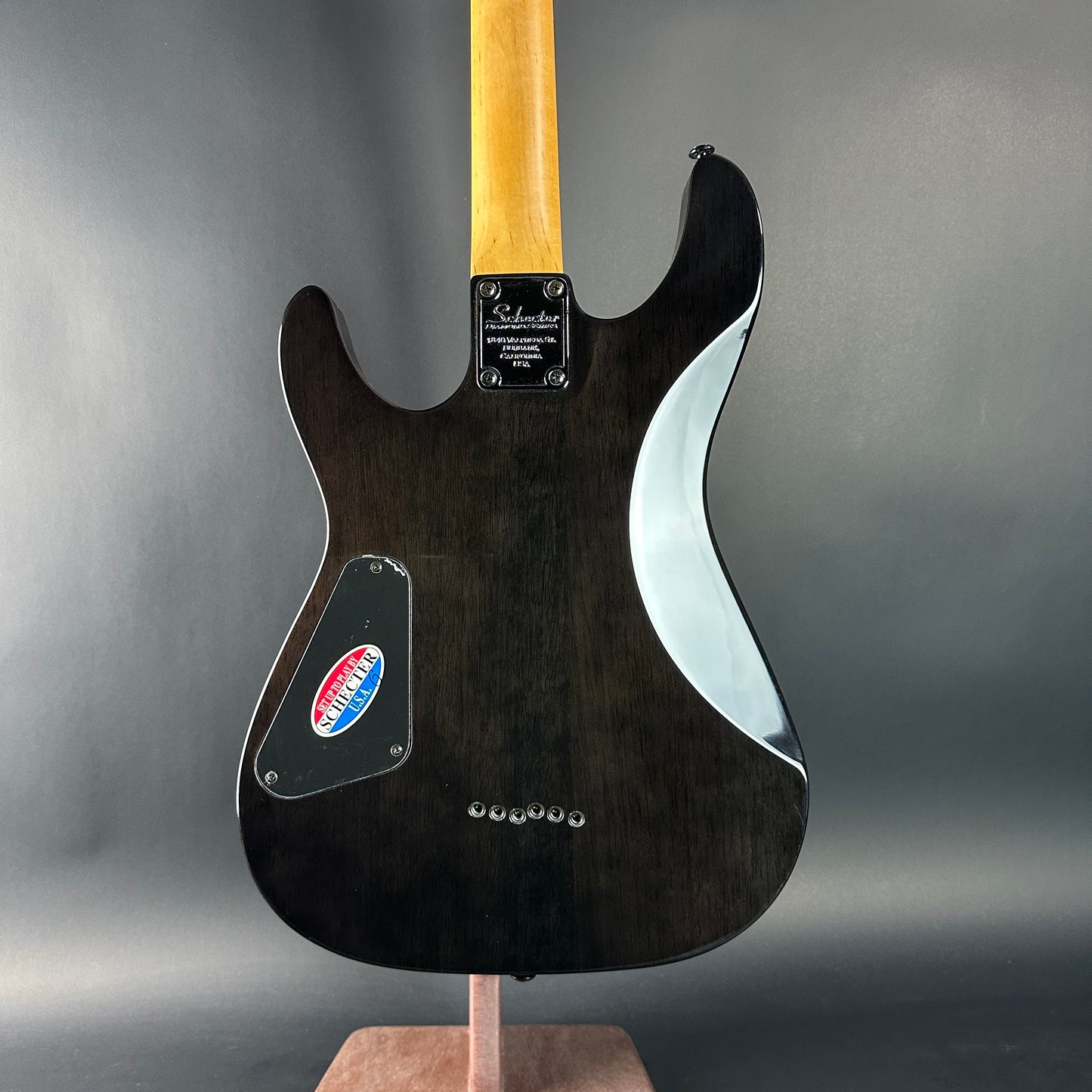 Black electric guitar on a gray background