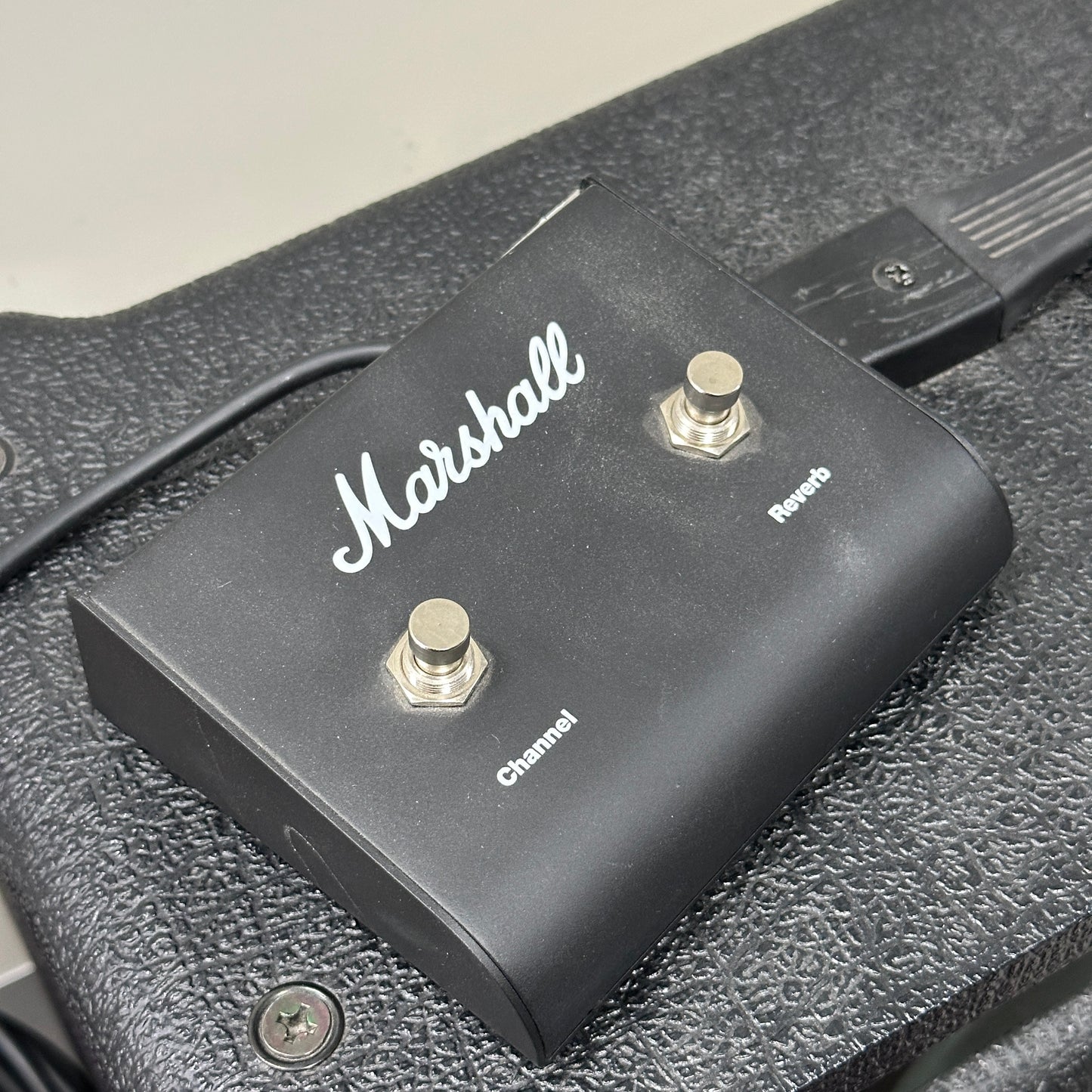 Marshall guitar effects pedal with two knobs on a textured surface