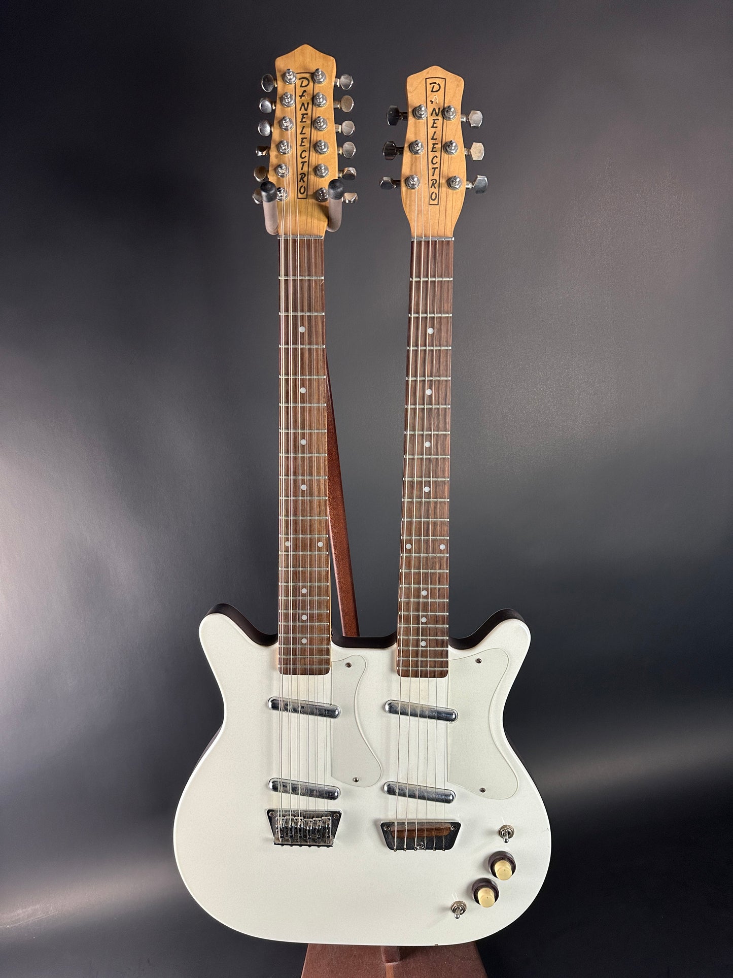 White electric guitar with two necks on a dark background