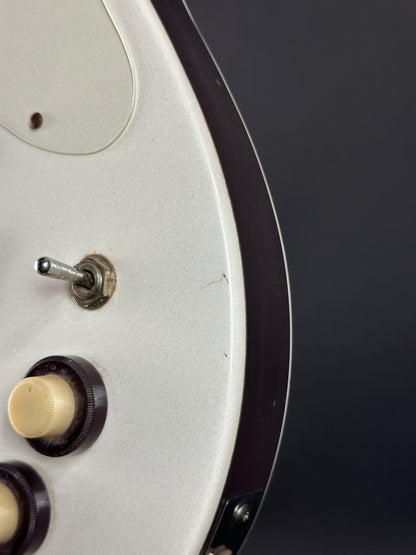 Close-up of a mechanical device with knobs and a switch on a dark background