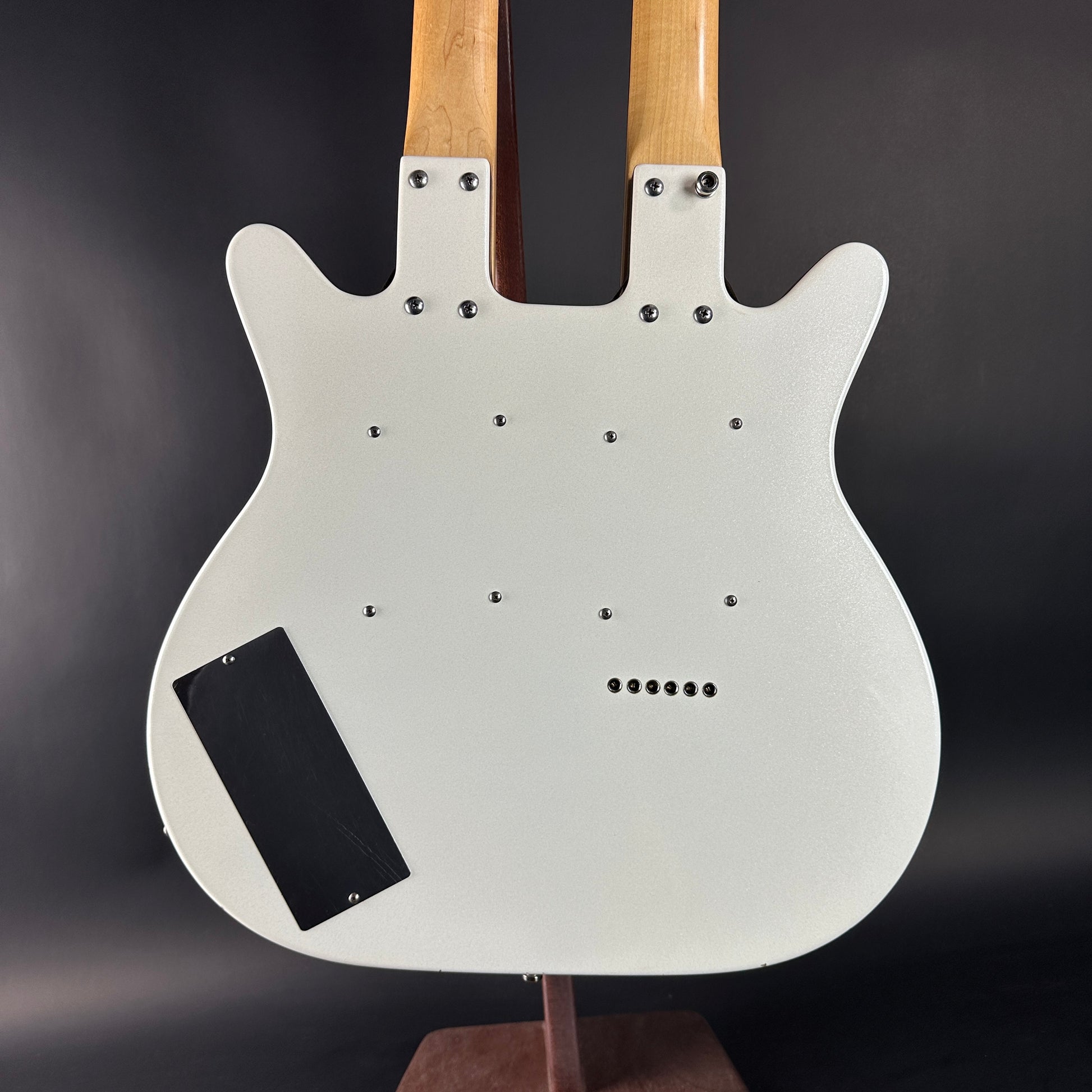 White electric guitar body with wooden neck on a dark background