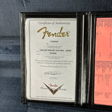Fender certificate of authenticity in a leather case on a gray surface