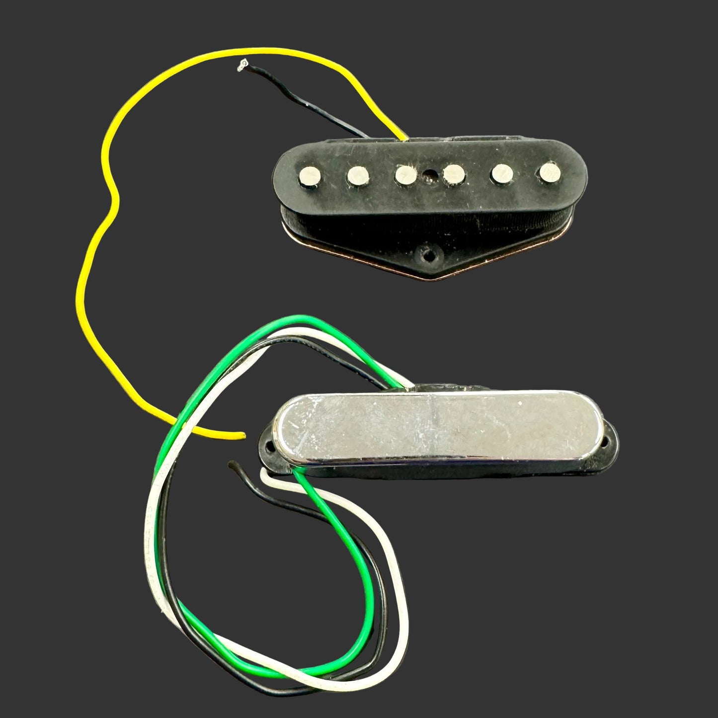 Two guitar pickups with wiring on a gray background