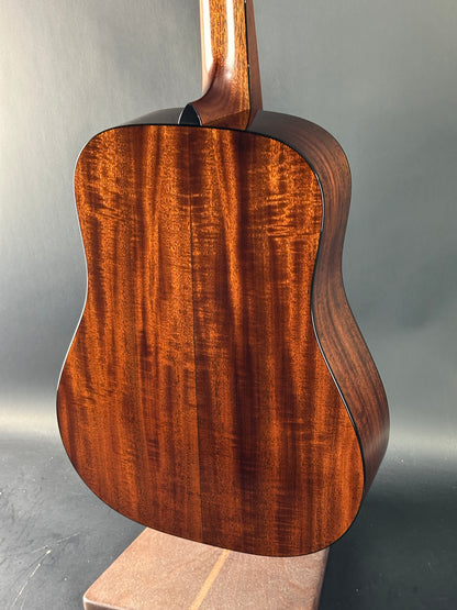 Close-up of a wooden acoustic guitar body on a gray background