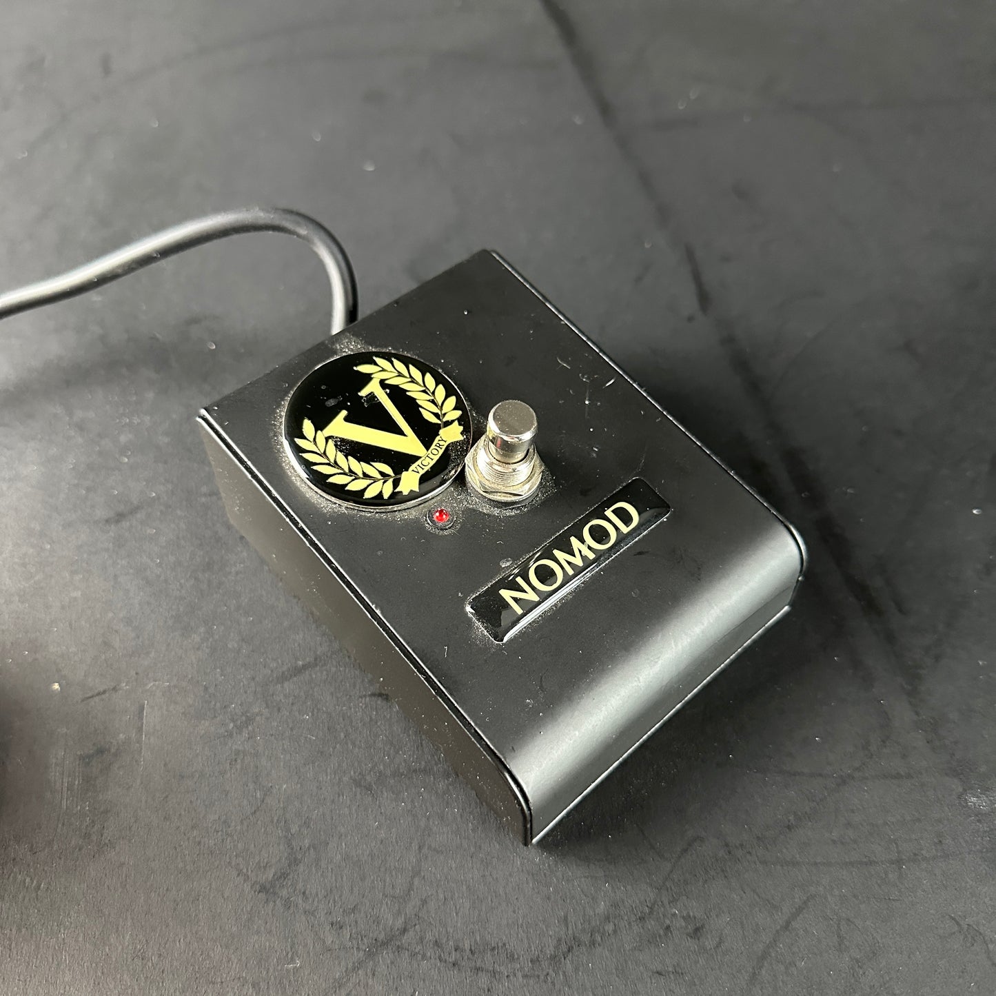 Black pedal with 'NOMOD' branding on a dark surface