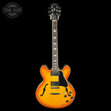 Electric guitar with a sunburst finish on a black background, featuring the Tone Shop logo.
