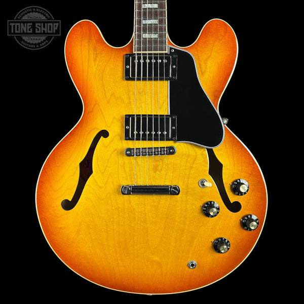 Electric guitar with a sunburst finish on a black background, featuring the Tone Shop logo.