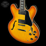 Electric guitar with a sunburst finish on a black background, featuring the Tone Shop logo.