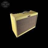 A vintage-style guitar amplifier with a cream-colored fabric grille and a brown speaker mesh front, shown at an angle on a solid black background. A Tone Shop watermark is visible in the top-left corner.