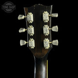 Close-up of a guitar headstock showing six silver tuning pegs on a dark brown wooden neck against a black background, with a Tone Shop watermark in the top left corner.
