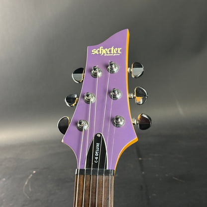Guitar headstock with 'Schecter' branding on a dark background