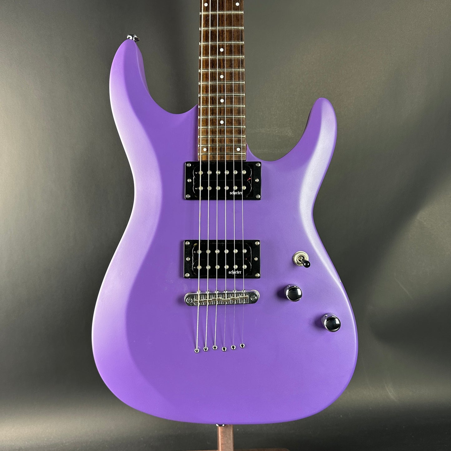 Purple electric guitar on a gray background