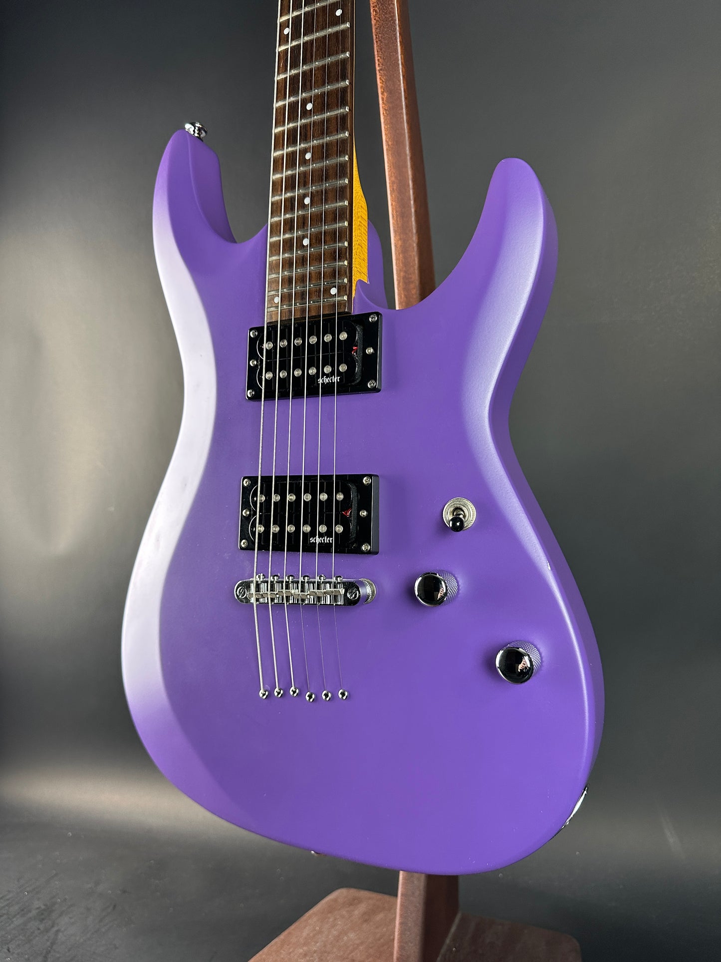 Purple electric guitar on a gray background