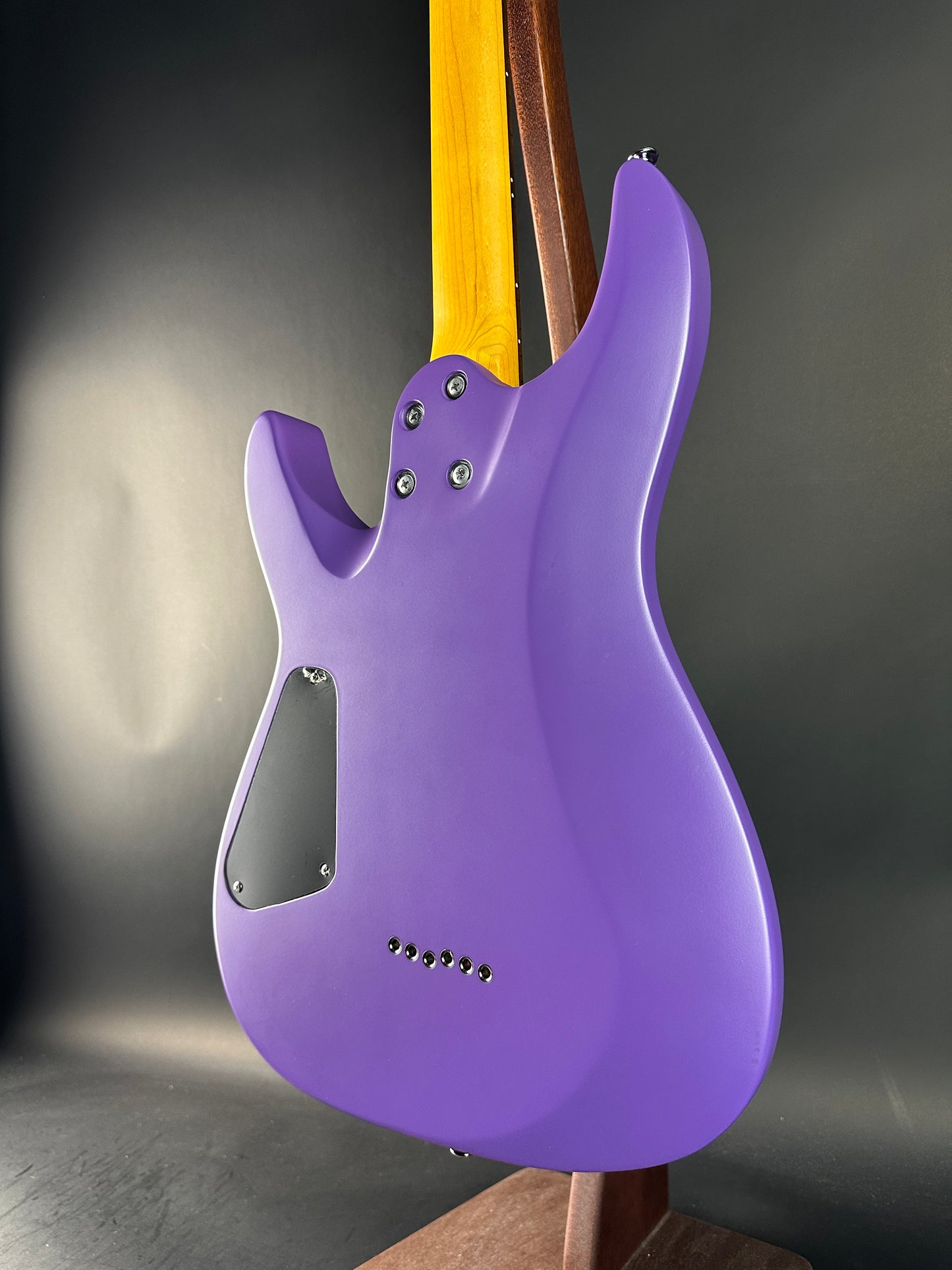 Purple electric guitar body on a dark gray background