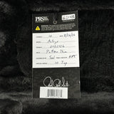 A product tag for aPRS Studio instruments Astyr10 top stringed instrument, set against a black furry background. The tag is white and black with handwritten details and a signature at the bottom.