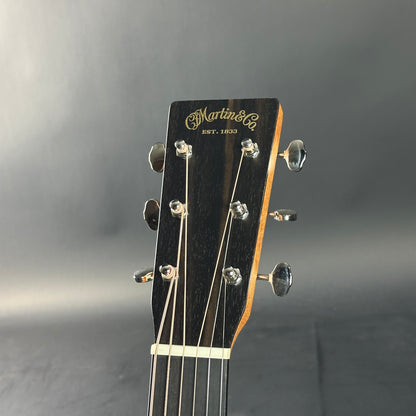 Guitar headstock with Martin & Co logo on a gray background