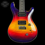 A double-cutaway electric guitar with a vibrant rainbow flame finish transitioning from purple and blue at the top to orange and red at the bottom, shown against a solid black background.