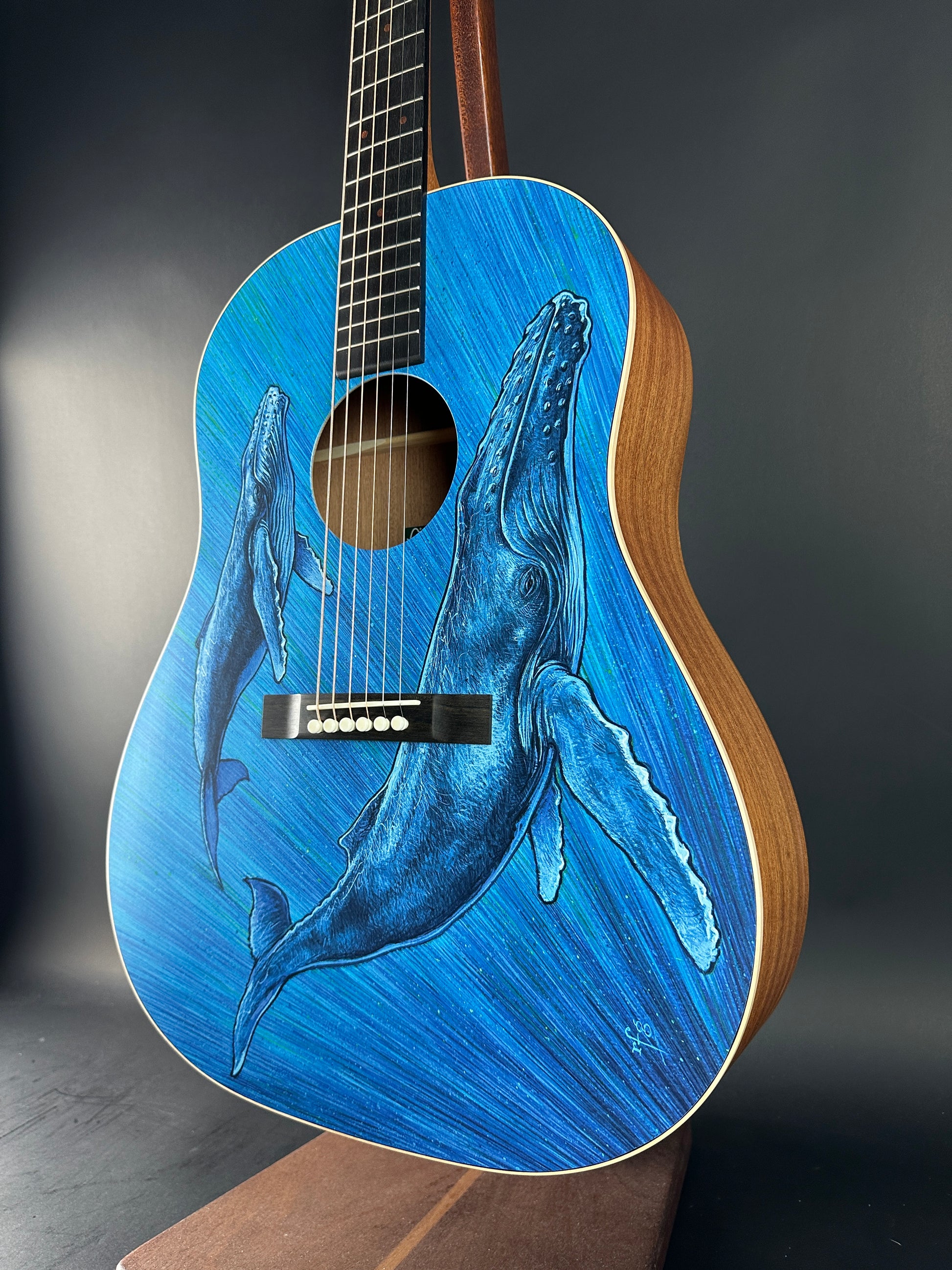 Guitar with a blue whale design on a dark background