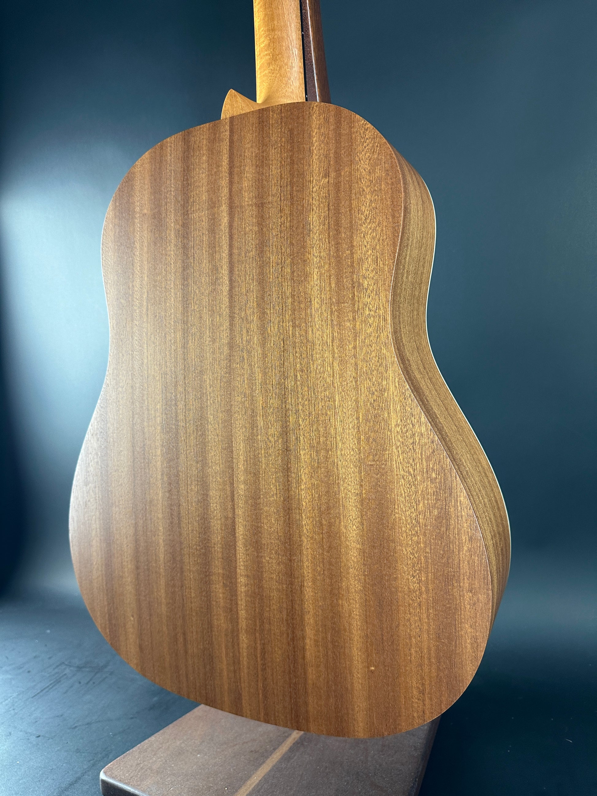 Close-up of a wooden guitar body on a dark background