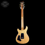 A natural wood electric guitar shown from the back against a solid black background, with a Tone Shop watermark in the upper left corner.