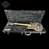 An electric guitar with a dark brown flamed maple body and a light maple neck, displayed inside an open black hard case on a black background. A Tone Shop watermark is visible in the top left corner.