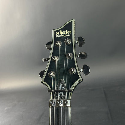 Guitar headstock with 'Schecter' branding on a gray background