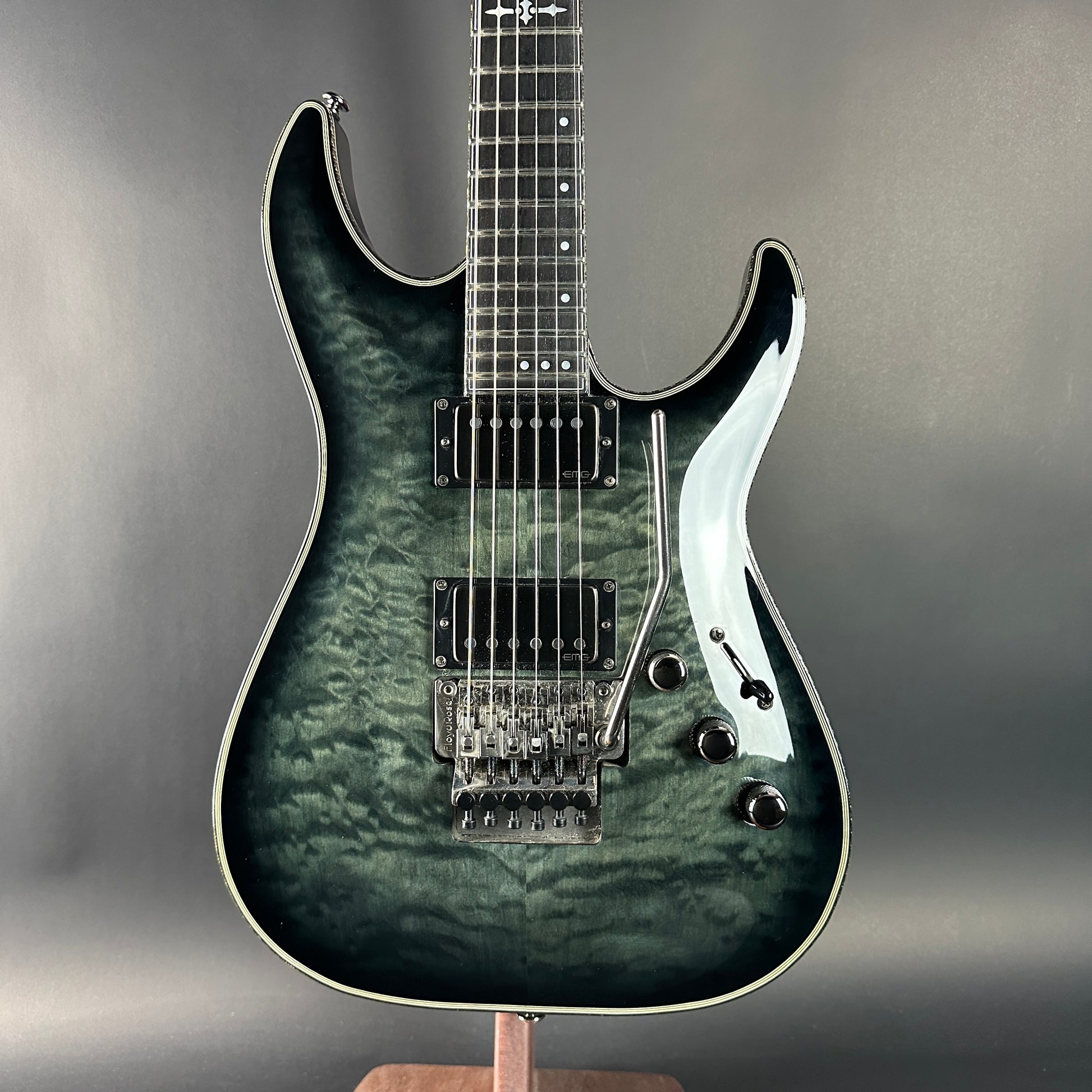 Electric guitar with a dark green and black finish on a gray background