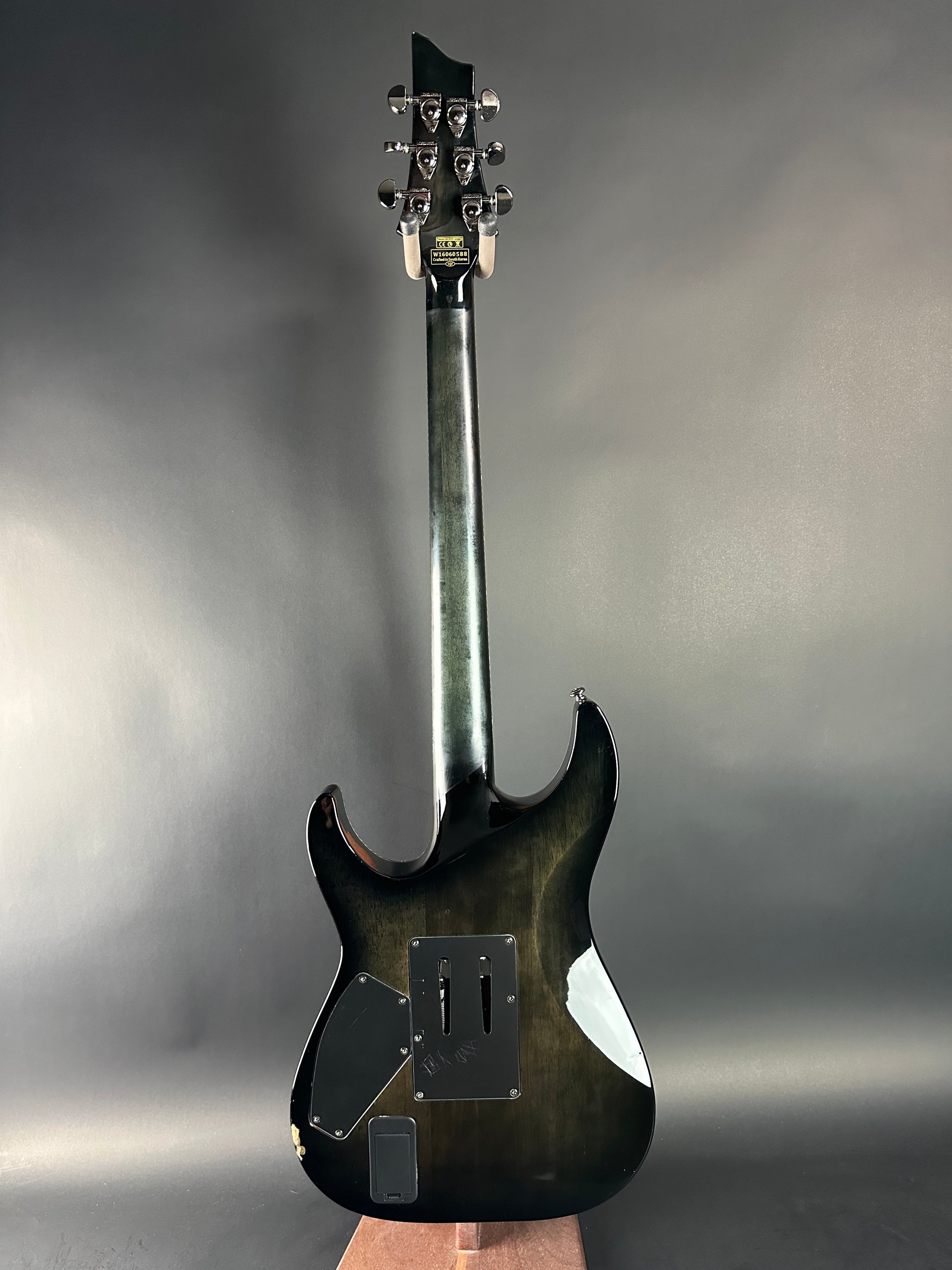 Electric guitar held against a gray background