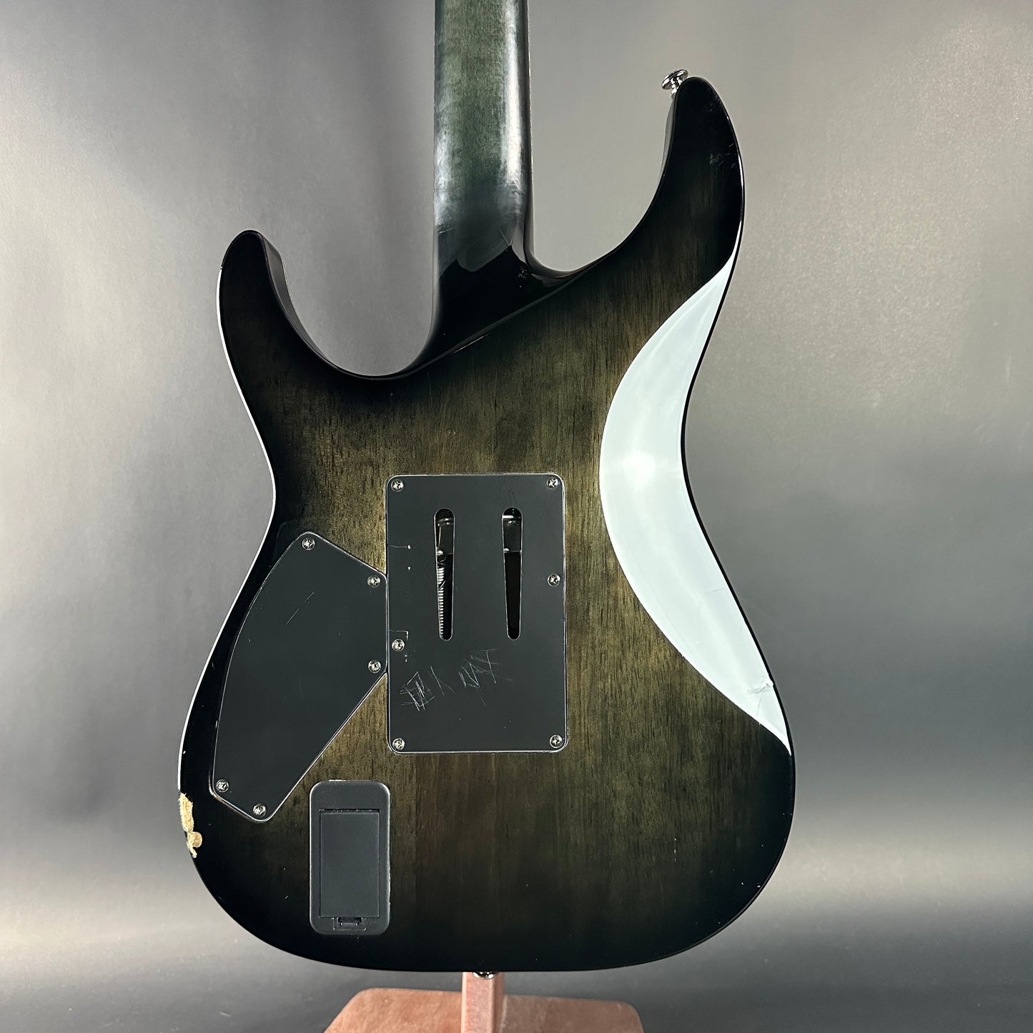 Close-up of a guitar body with a wavy design on a gray background