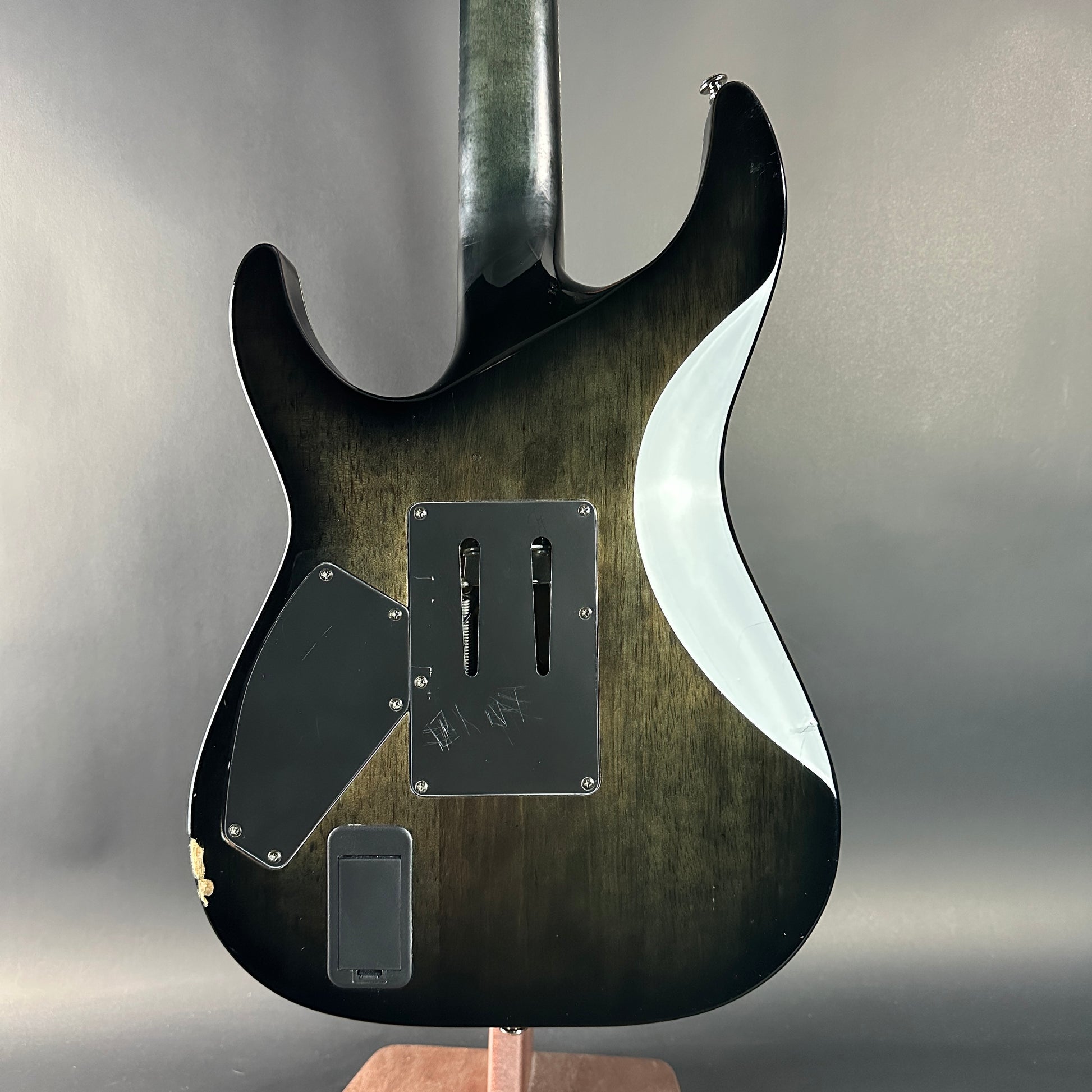 Close-up of a guitar body with a wavy design on a gray background