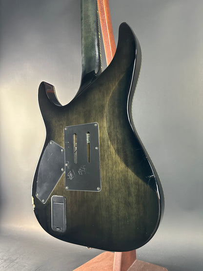 Guitar body with a focus on the back and bridge area against a neutral background