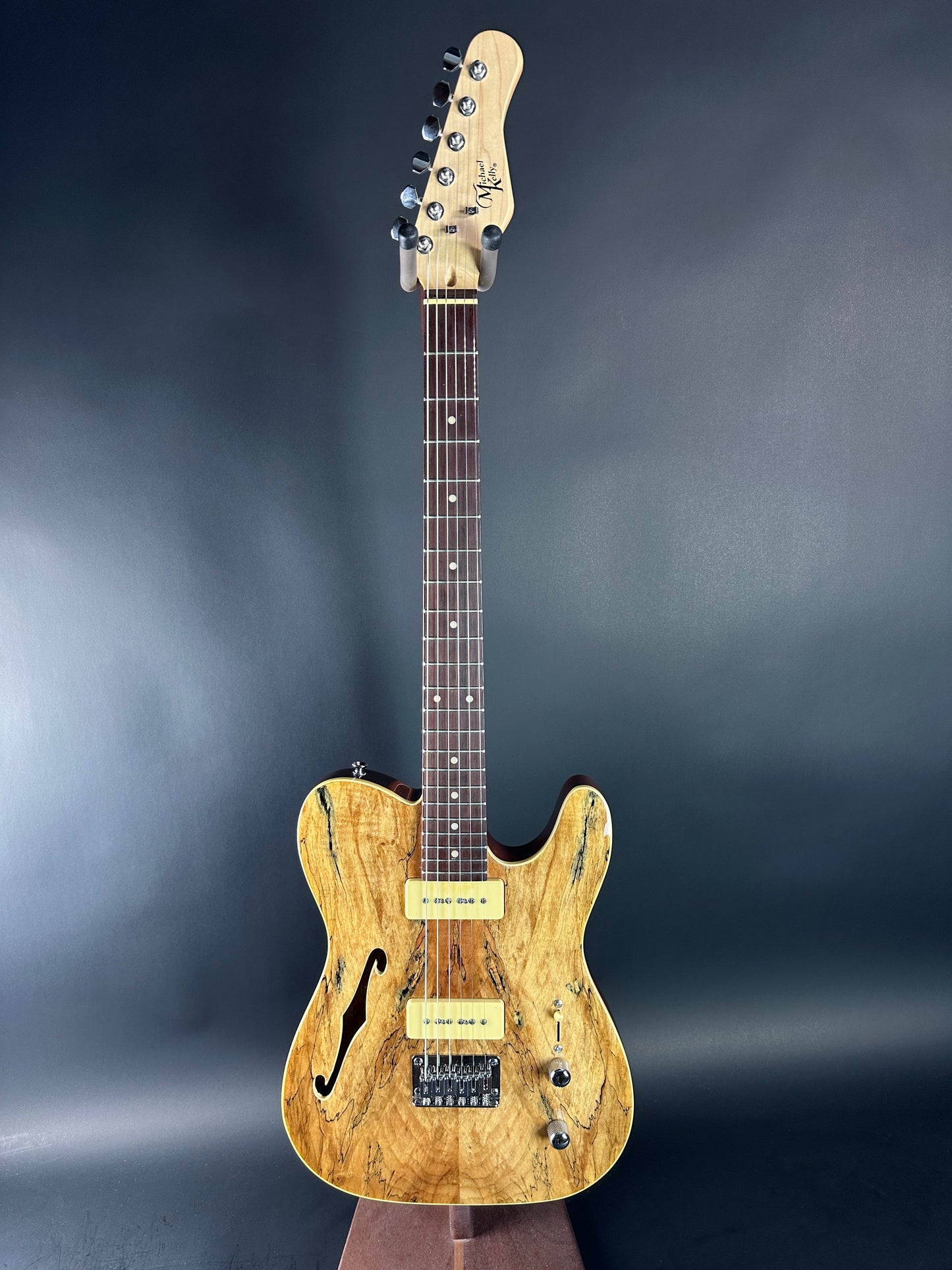 Wooden electric guitar on a dark gray background