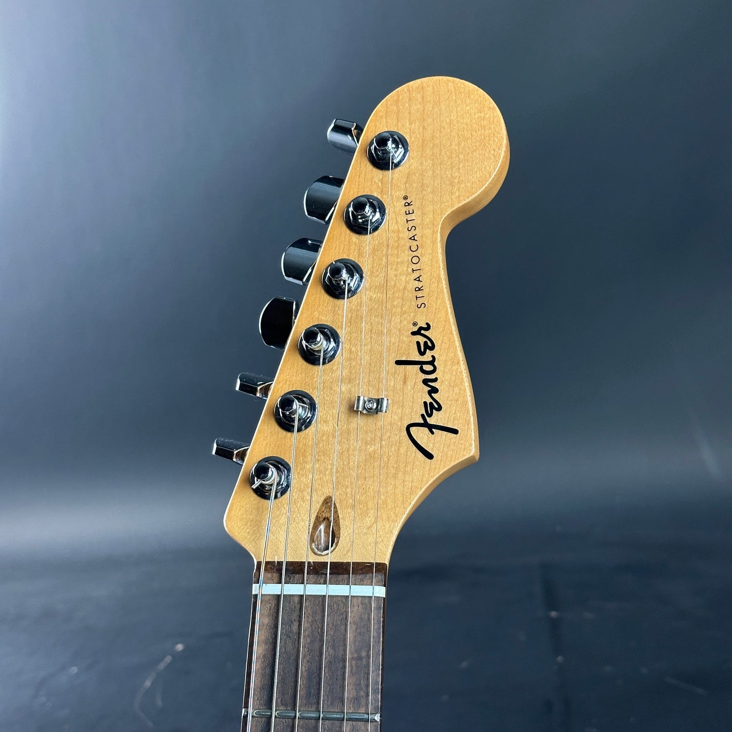 Fender Stratocaster guitar headstock on a dark background