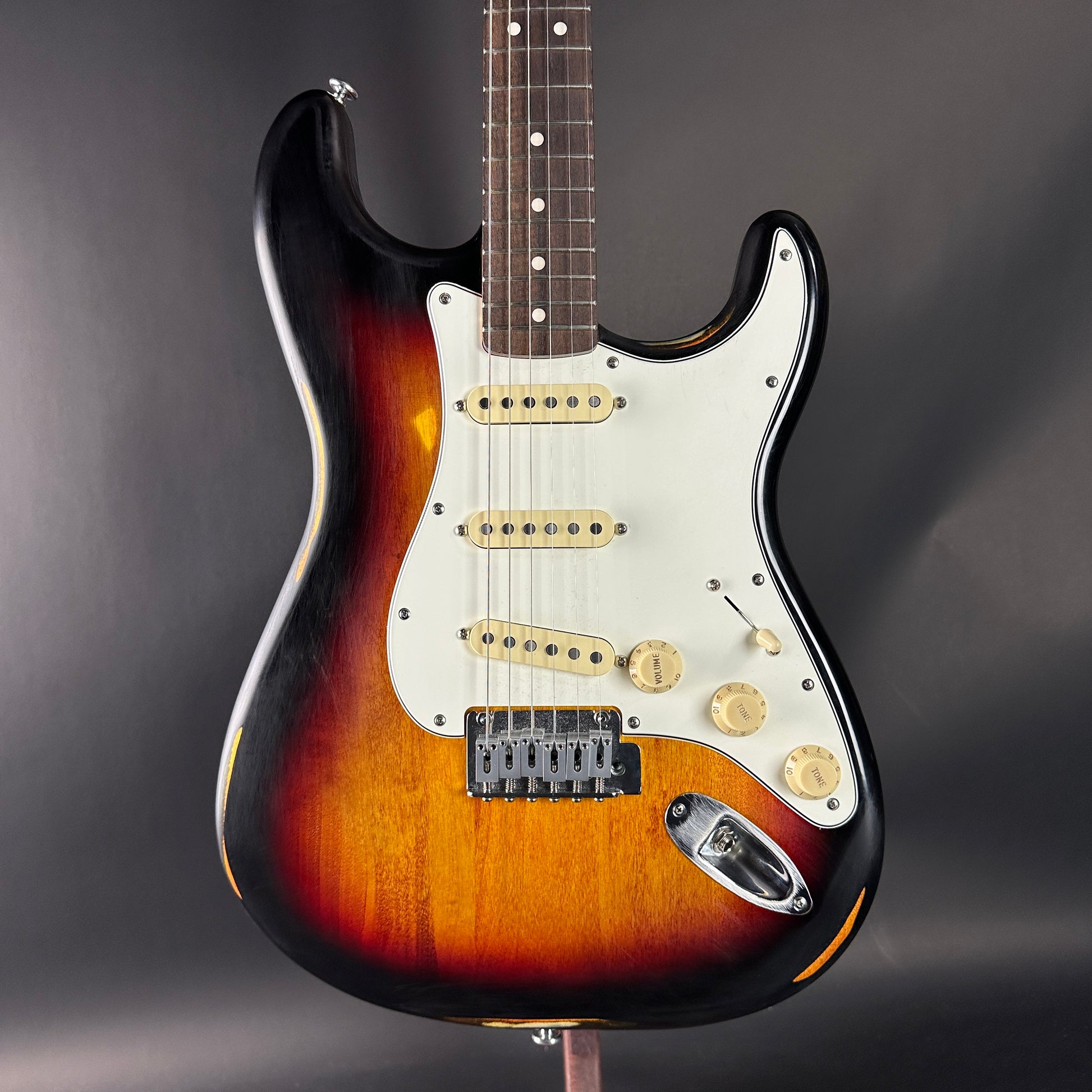 Electric guitar with a sunburst finish on a dark background