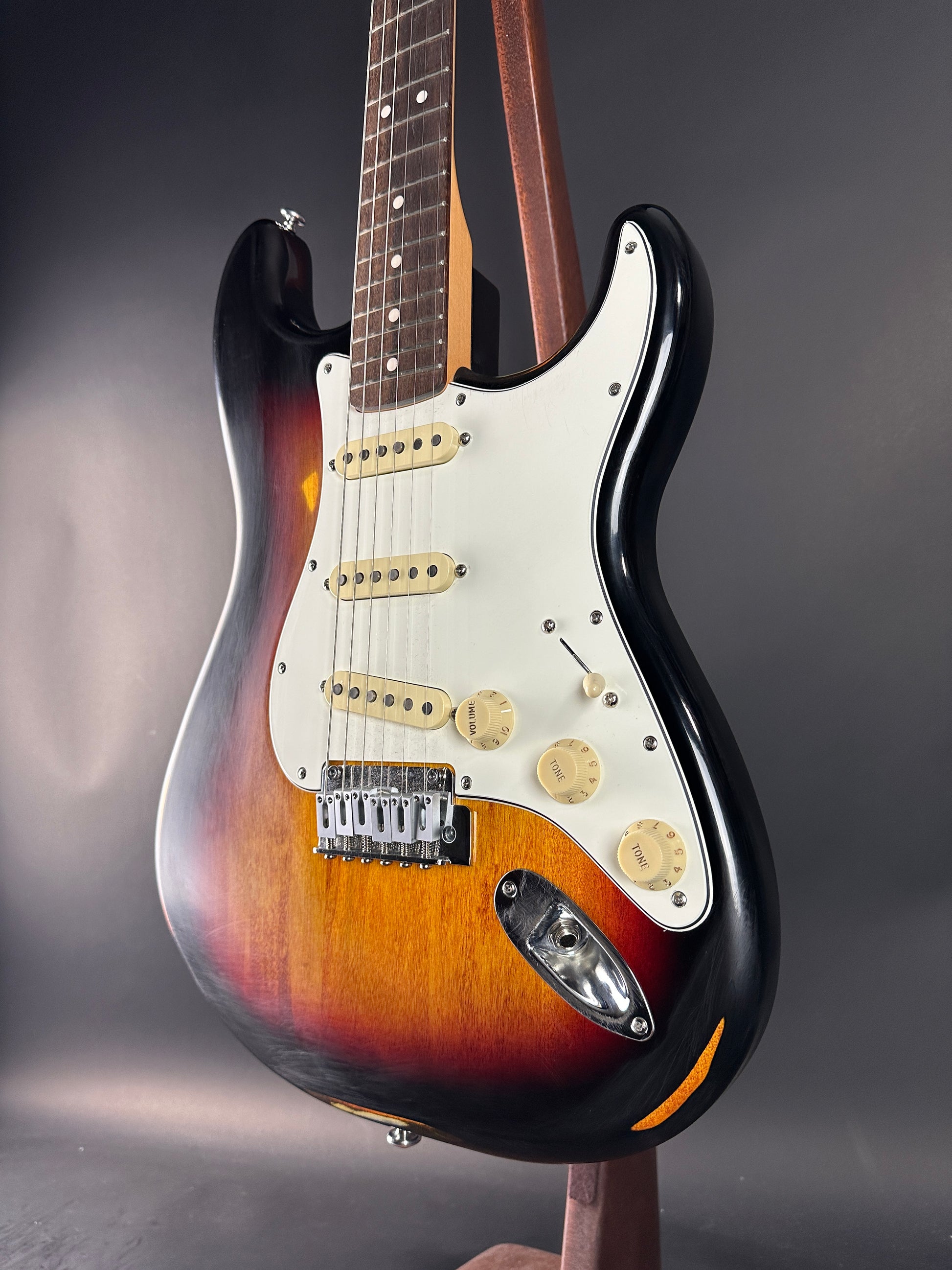 Fender Stratocaster guitar with sunburst finish on a reflective surface