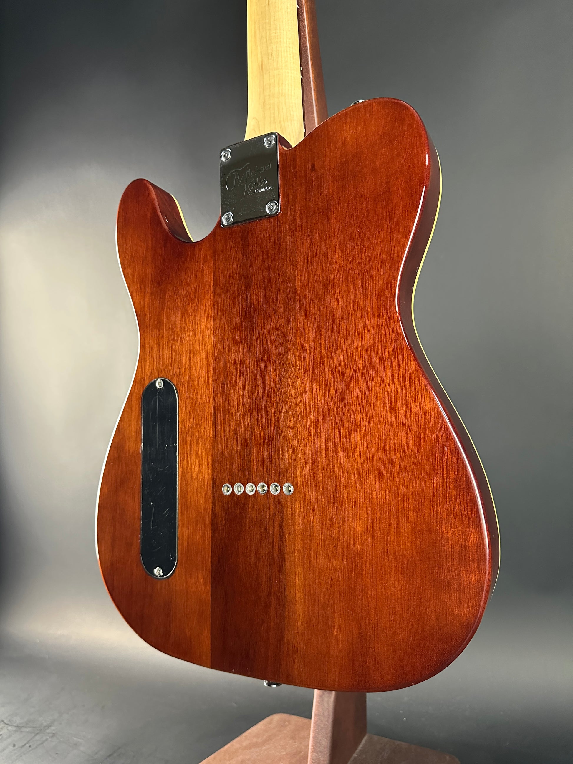 Wooden electric guitar body on a gray background