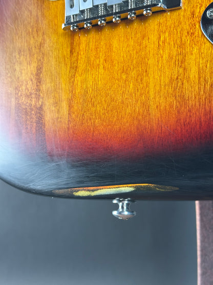 Close-up of a guitar's neck and headstock with a gradient finish.