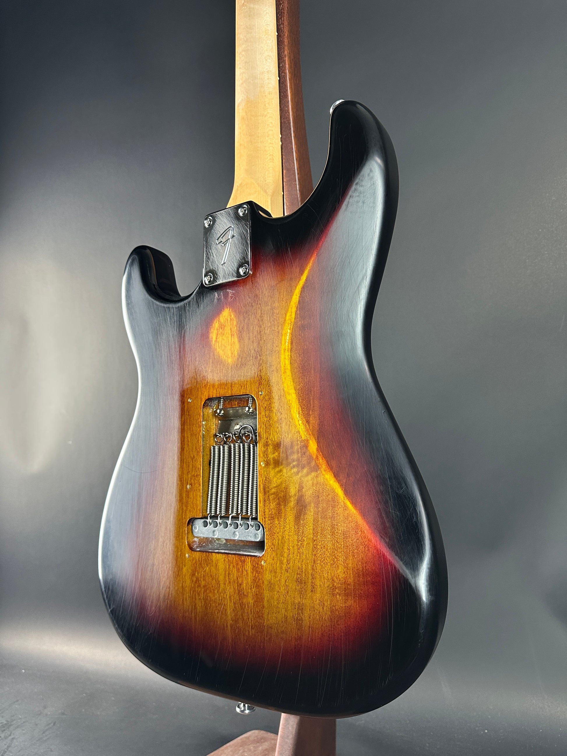 Close-up of a guitar body with a sunburst finish on a gray background
