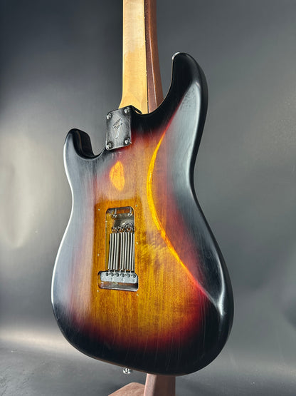 Close-up of a guitar body with a sunburst finish on a gray background