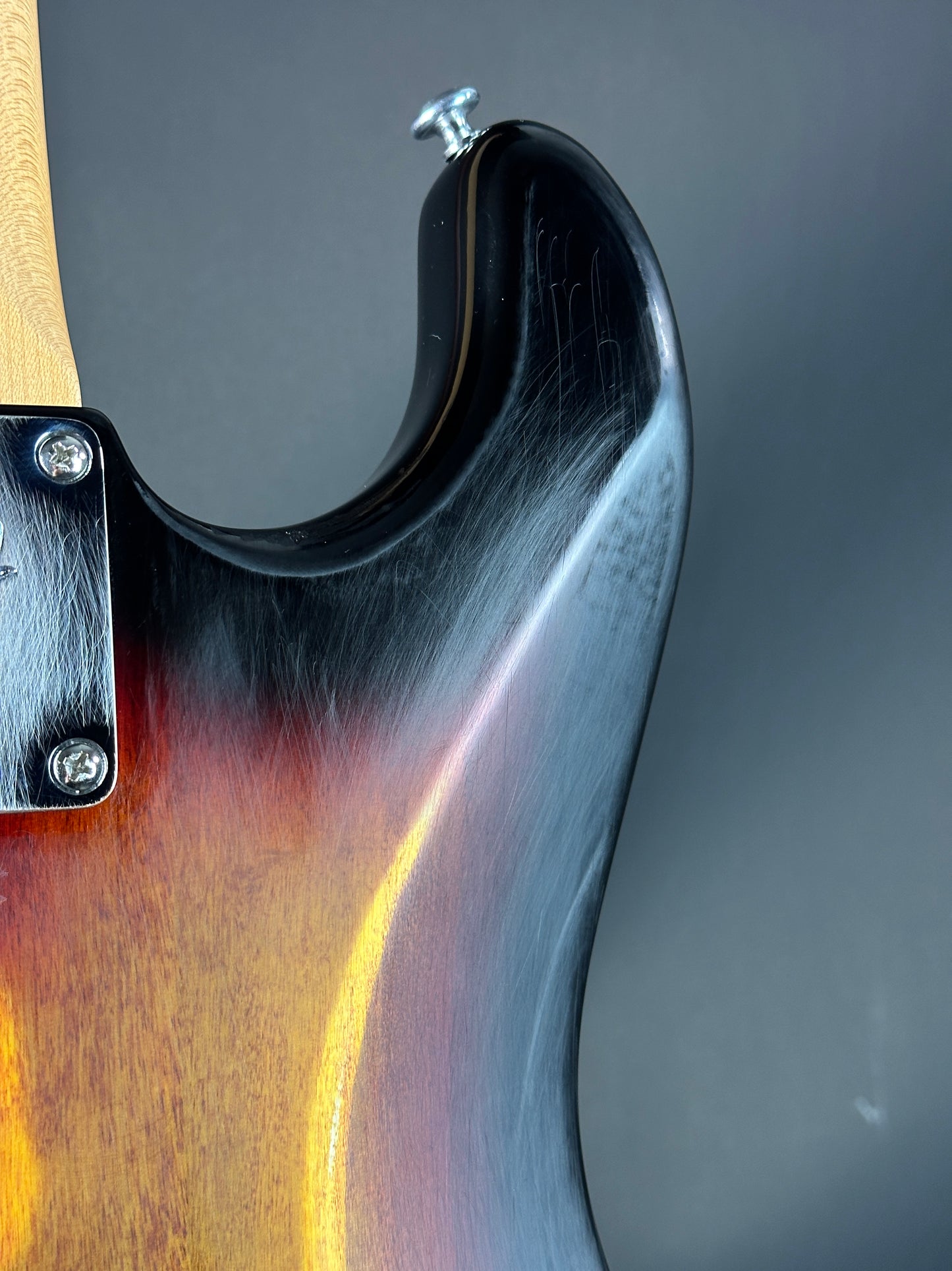 Close-up of a guitar's neck and headstock with a blurred background