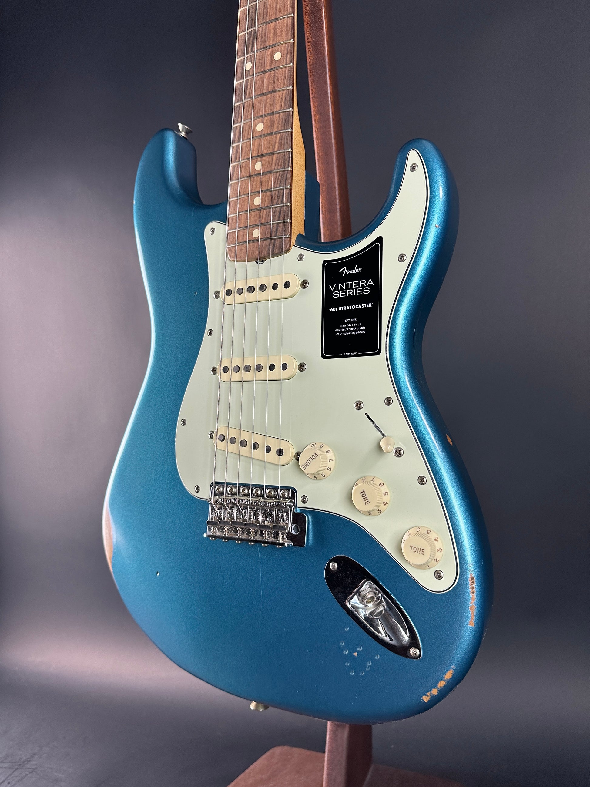 Blue electric guitar with a Fender logo on a dark background