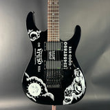 Black electric guitar with white designs and text on a gray background