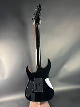 Black electric guitar on a reflective gray surface