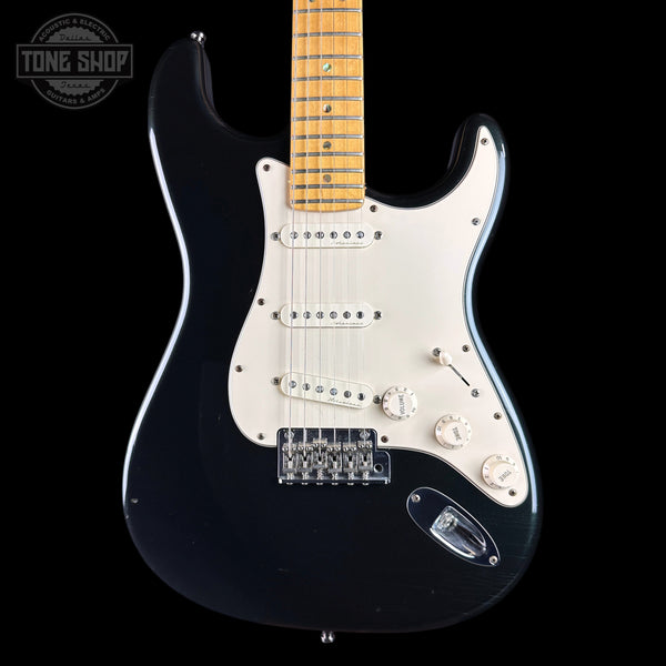 A black electric guitar with a white pickguard and maple neck, photographed against a solid black background. A Tone Shop watermark is visible in the top-left corner.