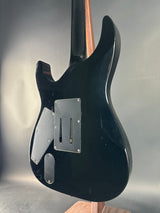 Black electric guitar body on a reflective surface with a neutral background