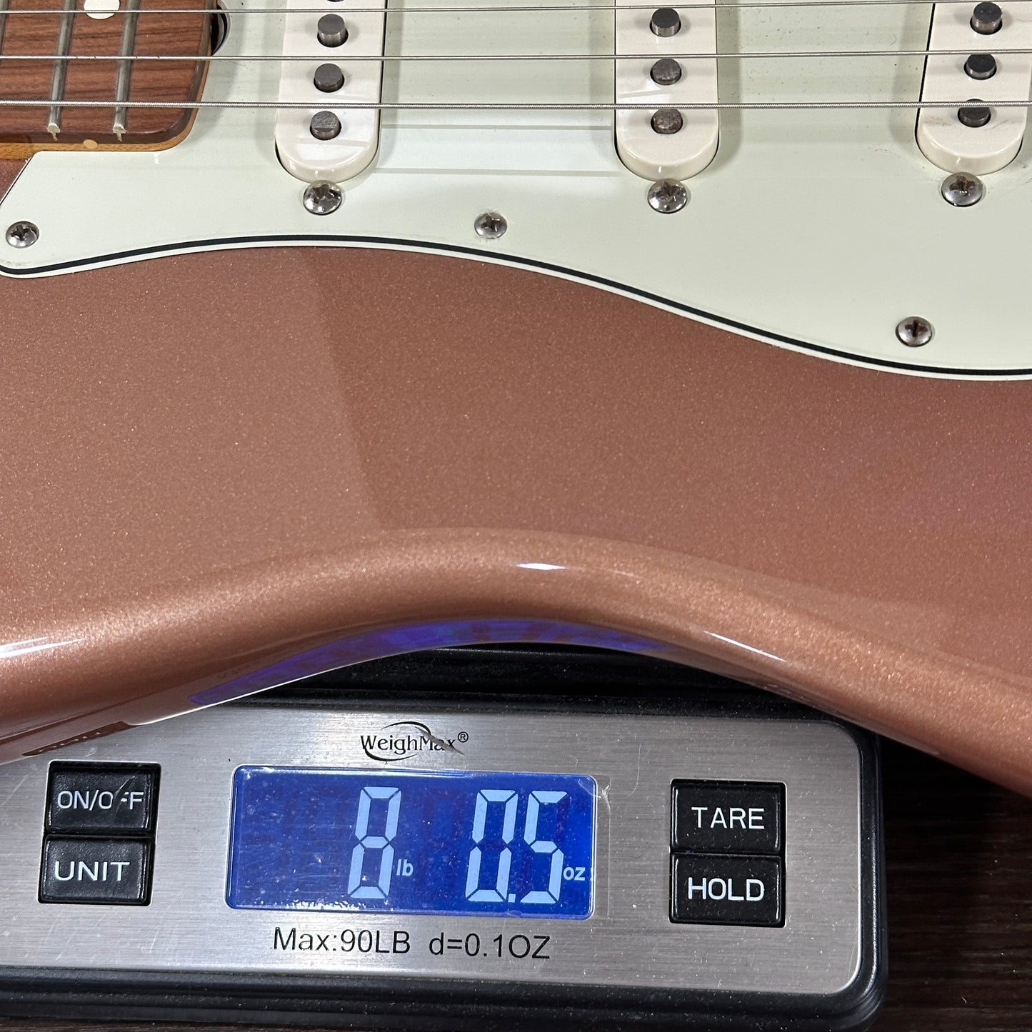 Guitar on a digital scale displaying weight