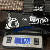 Electric guitar on a digital scale displaying weight, with 'Ouija' branding.