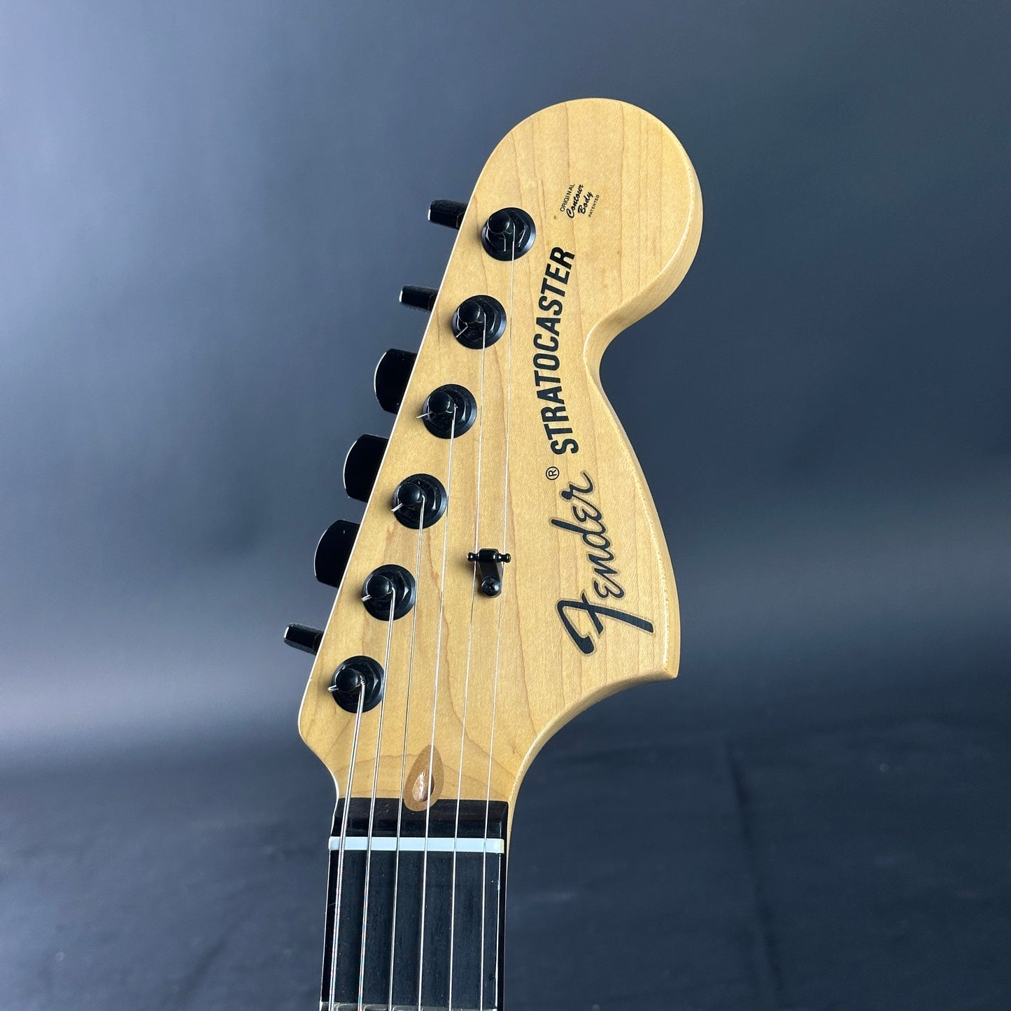 Fender Stratocaster guitar headstock on a dark background