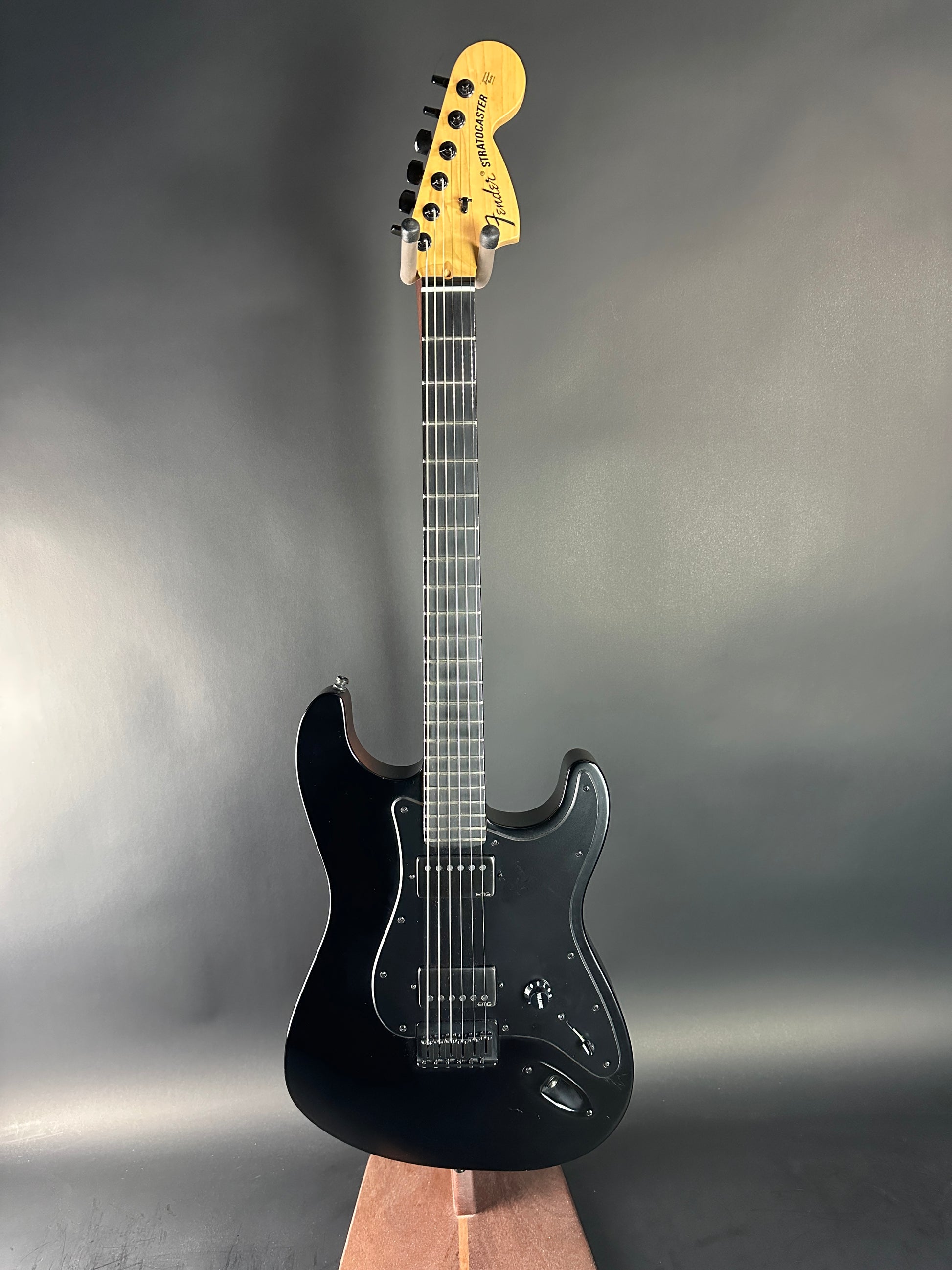 Black electric guitar on a gray background