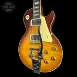 A Gibson Les Paul Custom electric guitar with a natural flame maple top, cream pickguard, and gold hardware, shown against a solid black background with a Tone Shop watermark in the top-left corner.